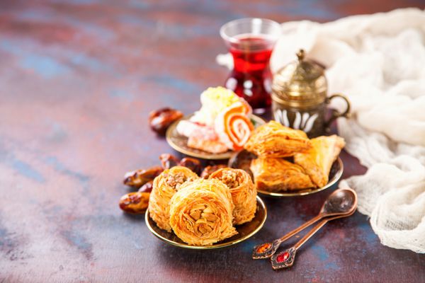 دسرهای سنتی عربی کونافه و باقلوا با عسل و آجیل تمرکز انتخابی فضای کپی