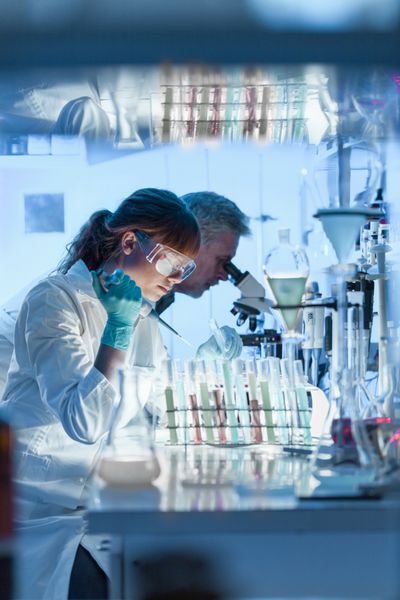 محققان مراقبت های بهداشتی که در آزمایشگاه علوم زیستی کار می کنند دانشمند پژوهشگر زن جوان و سرپرست ارشد مرد در حال تهیه و تجزیه و تحلیل اسلایدهای میکروسکوپی در آزمایشگاه تحقیقاتی