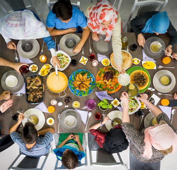 نمای بالای گردهمایی خانواده مسلمان برای خوردن غذای افطاری در ماه رمضان