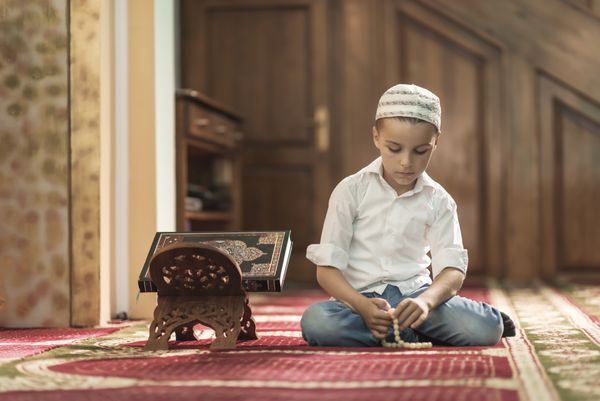 رمضان کریم پسر زیبای مسلمان در حال نماز در مسجد صلح و عشق در ماه مبارک رمضان مفهوم سبک زندگی