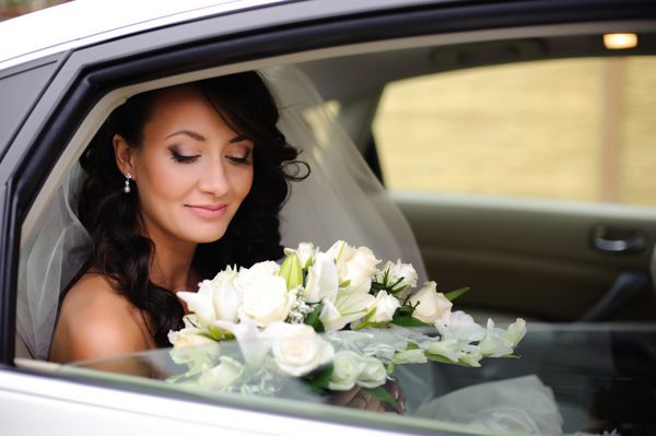 پرتره نزدیک از یک عروس خجالتی زیبا در پنجره ماشین