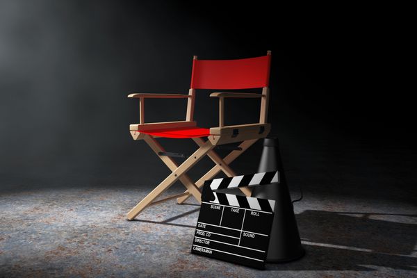 مفهوم صنعت سینما صندلی کارگردان قرمز فیلم کلاپر و مگافون در نور حجمی روی پس‌زمینه مشکی رندر سه بعدی