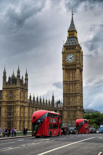 لندن بریتانیا - 29 مه 2017 اتوبوس های قرمز در مقابل بیگ بن نام مستعار زنگ بزرگ ساعت در انتهای شمالی کاخ وست مینستر در لندن