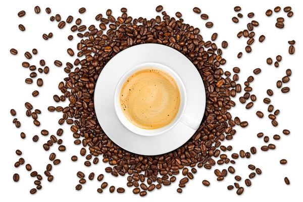 فنجان قهوه روی دانه های جدا شده در پس زمینه سفید