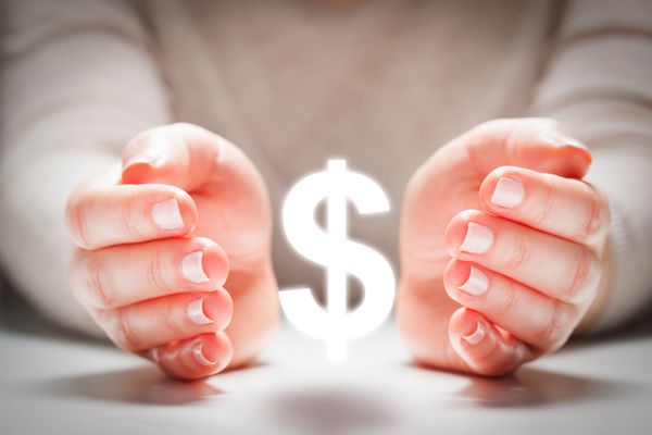 علامت دلار بین دستان زن به نشانه محافظت ثبات ارز