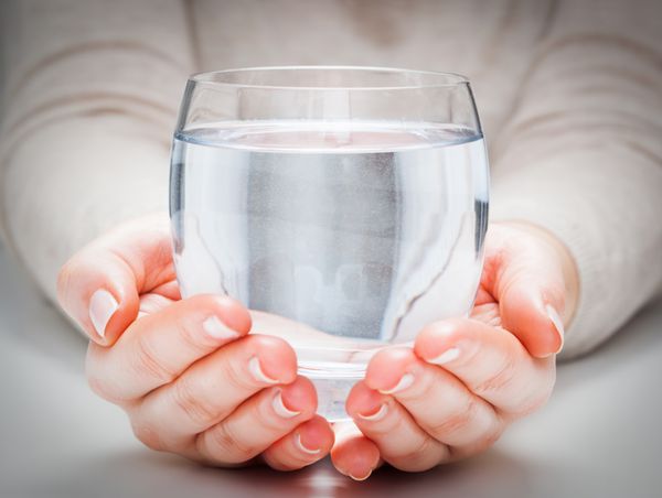 یک لیوان آب معدنی تمیز در دستان زن حفاظت از محیط زیست نوشیدنی سالم