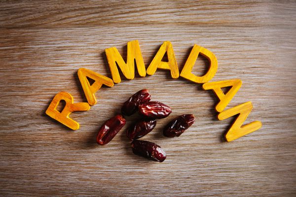 کلمه رمضان با حروف چوبی و خرمای خشک روی میز