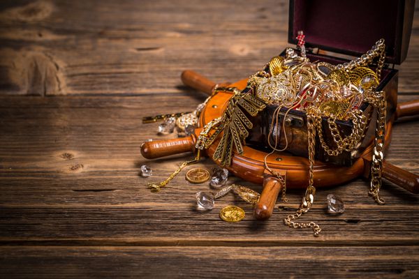 سینه دزدان دریایی با جواهرات طلایی در زمینه چوبی