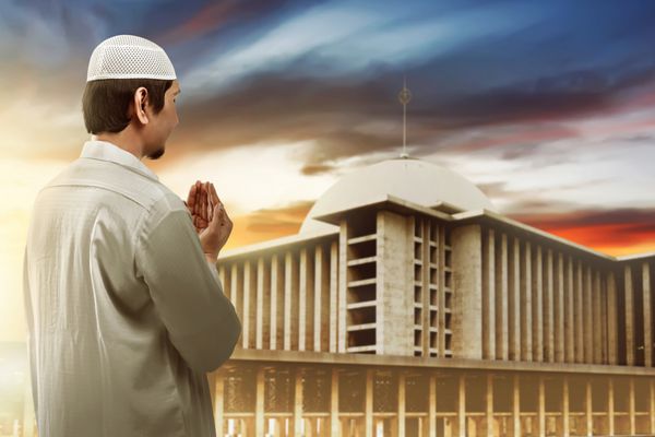 مرد جوان مسلمان در حال نماز خواندن به مسجد
