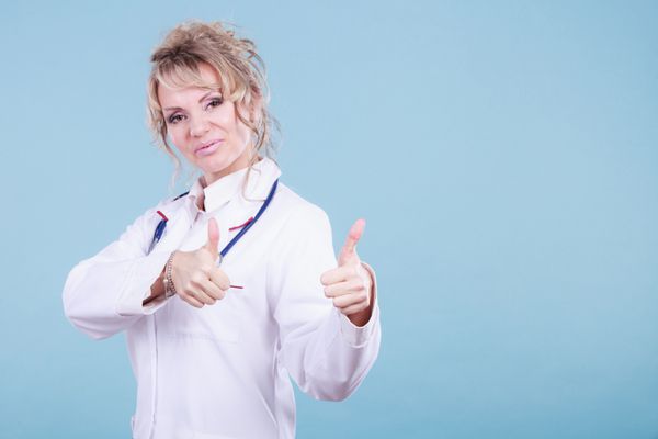 پزشک زن که انگشت شست را نشان می دهد