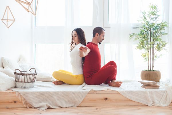 مرد و زن در حال تمرین یوگا در خانه