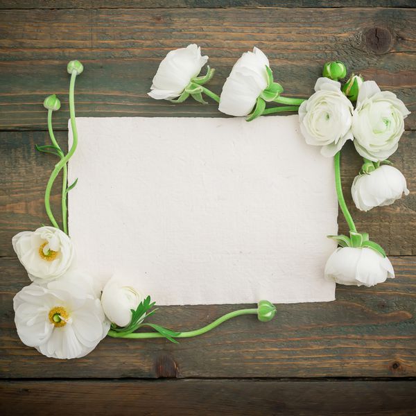 کارت خوشنویسی کاغذی و گل های سفید در زمینه چوب تخت خوابیده نمای بالا پس زمینه قدیمی