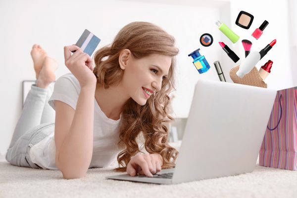 خرید آنلاین زن جوان با کارت اعتباری و لپ تاپ در خانه