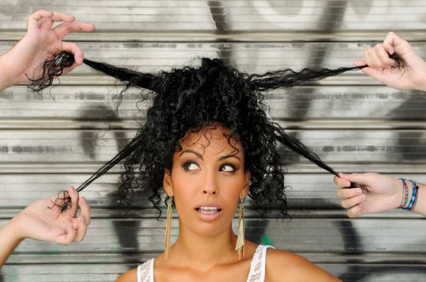 زن جوان سیاه‌پوست مدل موی آفریقایی در پس‌زمینه شهری