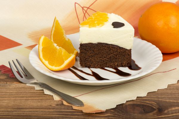 یک تکه کیک براونی با خامه و پرتقال