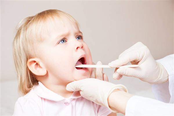 معاینه پزشکی کودک با چوب دهان