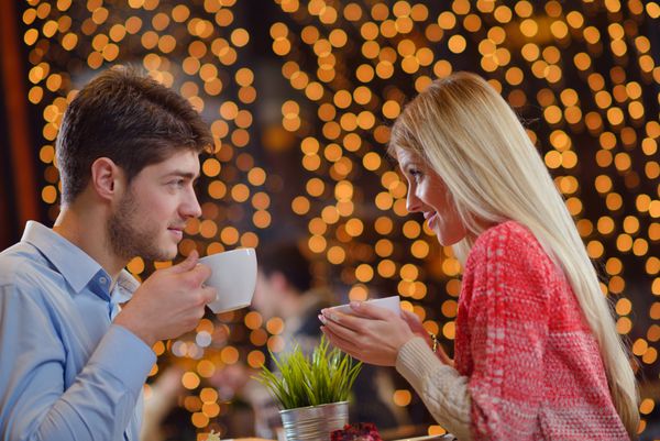 شب عاشقانه تاریخ در رستوران شاد زن جوان با چای شیشه ای و کیک