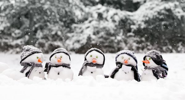 آدم برفی کوچک در یک گروه کارول خواننده در برف