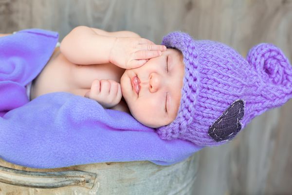 رویای شیرین نوزاد تازه متولد شده در کلاه بنفش