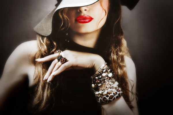 زن جوان زیبا مدل با لب قرمز کلاه و کت و شلوار یکپارچهسازی با سیستمعامل و جواهرات ارسال یک بوسه smooch نزدیک