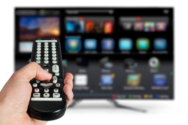 تلویزیون هوشمند و دست با فشار دادن کنترل از راه دور