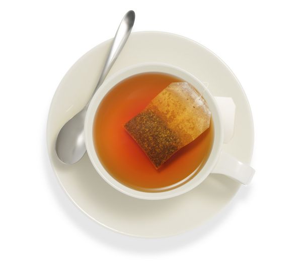 دیدگاه بالای یک فنجان چای با کیسه چای جدا شدن بر روی سفید