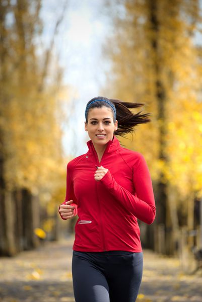 زن خوش شانس در پاییز پارک شهر ورزشکار زن در فصل پاییز در فضای باز دونده قفقازی