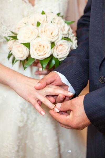 عروس لباس عروسی بر روی انگشت عروس نزدیک