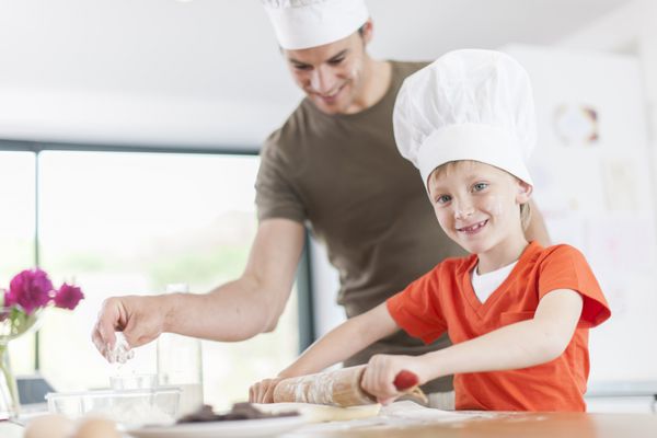 یک پدر و پسرش یک کیک را در آشپزخانه آماده می کنند