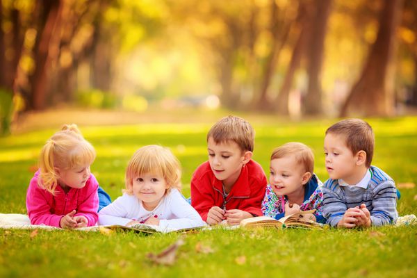 کودکان در طبیعت خواندن کتاب خارج از منزل دروغ گفتن بر چمن