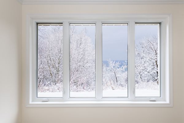 پنجره بزرگ چهار پنجره ای که بر روی درختان برف را در فصل زمستان پوشانده است