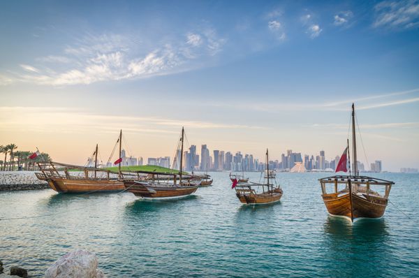Dhows moored off Museum Park in central Doha Qatar Arabia with some of the buildings from the city