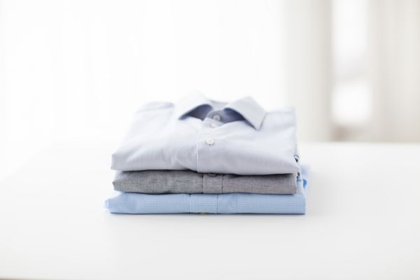 اتو کردن لباسشویی لباس خانهداری و مفهوم اشیاء نزدیک کردن پیراهن های روکش شده و براق روی میز در خانه