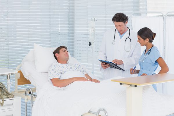 پزشکان مراقبت از بیمار در اتاق بیمارستان