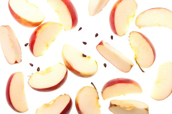 برش سیب سرخ تازه و دانه ها جدا شده بر روی زمینه سفید نمایش بالا