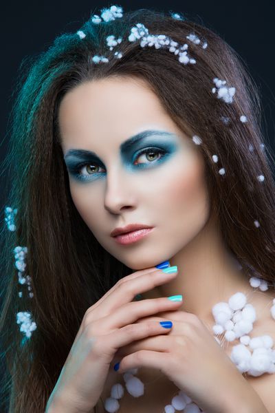 پرتره نزدیک از زن جوان زیبا با آرایش آبی و برف در مو