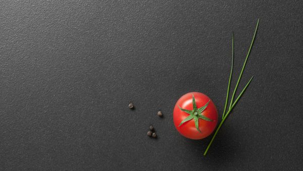 گوجه فرنگی قرمز با پیاز سبز در رنگ سیاه سربرگ برای وب سایت