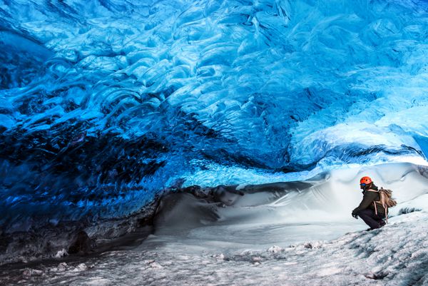 مسافر مرد با بهره گیری از نشانه های عجیب و غریب نشستن در غار یخ یخچال اسکات فله پارک ملی واتناجوکول طبیعت شگفت انگیز ایسلند