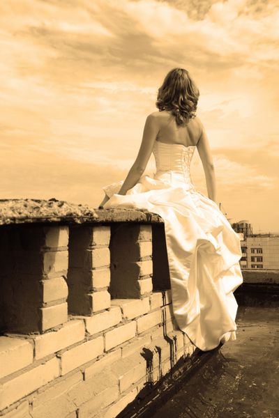 زن در یک لباس عروسی روی سقف پشت به دوربین اثر سپگی