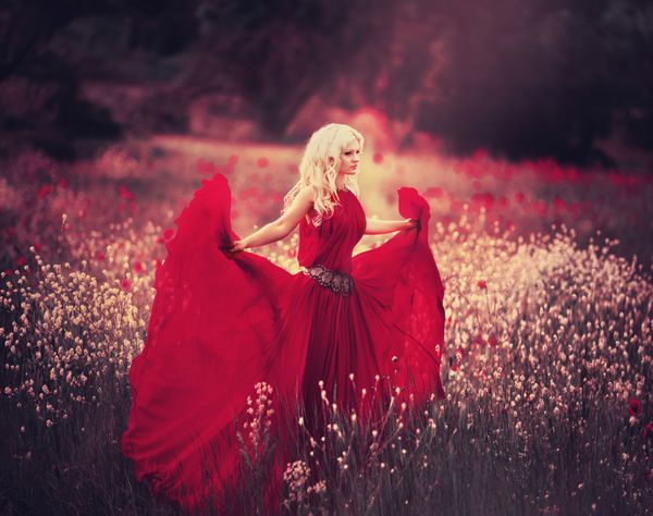 دختر زیبا در لباس قرمز در زمینه خشخاش