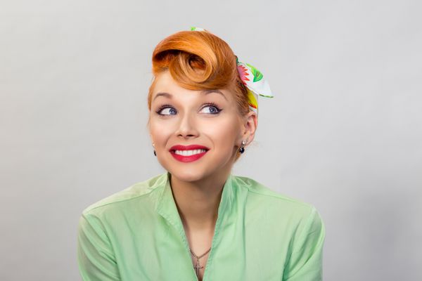 Daydreaming Closeup red head young woman pretty smiling girl green button shirt amazed pleasantly surprised thrilled dreaming about love looking up retro vintage 50