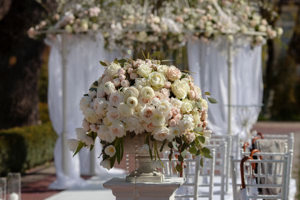 دسته گل های زیبا از گل های رز در یک گلدان عروسی مراسم عروسی را تنظیم کنید