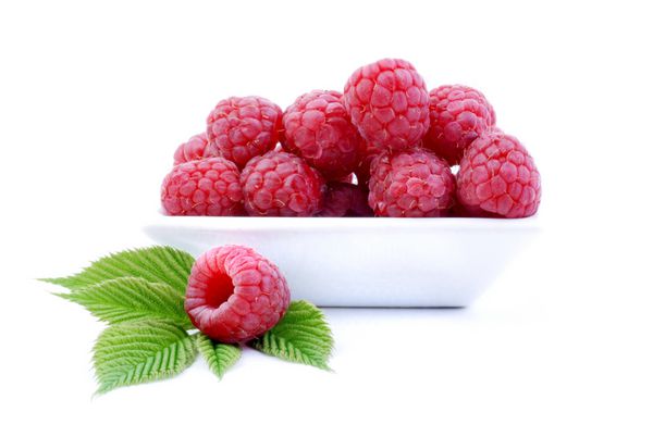 تمشک توت های قرمز شیرین جدا شده بر روی زمینه سفید میوه های تازه در کاسه سفید غذای خوشمزه