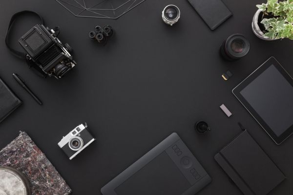 فضای کاری بر روی میز سیاه یک طراح خلاق یا عکاس با لپ تاپ قرص دوربین اشیاء دیگر الهام بخش و فضای کپی مفهوم شیک استودیو خانه از روند تکنولوژی