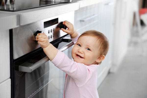 بچه کوچک با اجاق برقی در آشپزخانه