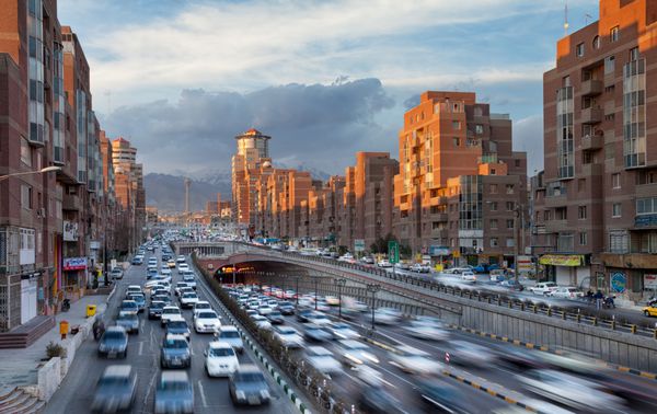 تهران ایران فوریه 19 2016 شهرکهای شهر تهران با ماشینهای عبور از تونل توحید در مقابل ساختمانهای ناواب Sunlit تونل توحید سومین بلندترین تونل شهری در خاورمیانه است