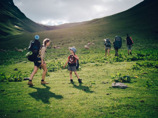 پیاده روی خانواده در کوه یک مادر جوان و پسرش در یک شب در تابستان زیبا در کوه ها با هم پیاده می شوند لبخند زدن و لذت بردن از وقت خود را با هم