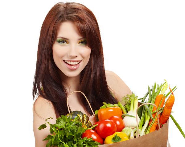 زن لبخند زدن با میوه ها و سبزیجات بیش از پس زمینه سفید