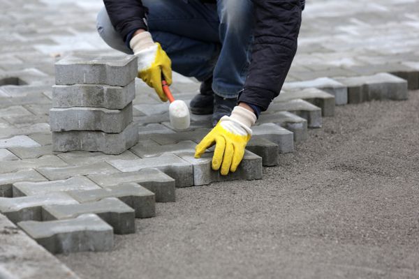 سنگ کارگر سنگ فرش در حال ساخت یک خیابان شهری است