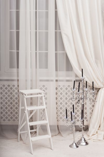 نردبان سفید در نزدیکی نقره ای نقره ای نقره ای در اتاق نشیمن با پنجره های بزرگ